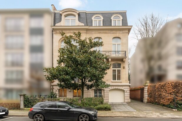 Palais urbain de 1911 avec une surface habitable de 1 000m², bureau, jardin, piscine intérieure et garage intégré.